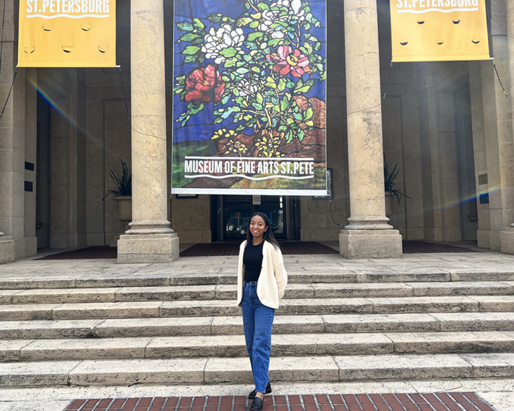 a woman standing in front of a building with flowers on it