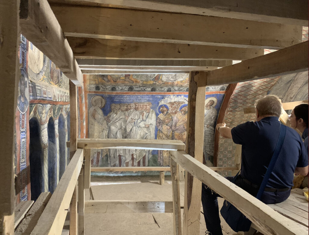 there is a man that is painting a mural on the wall