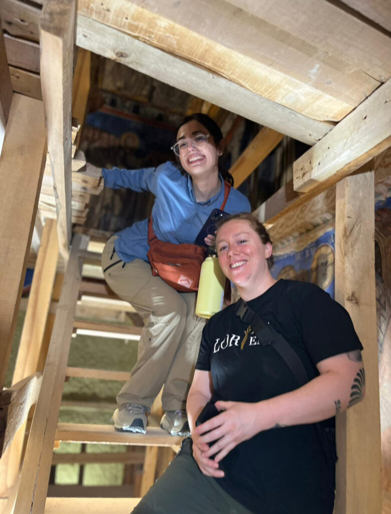 there are two women that are standing on the stairs of a building