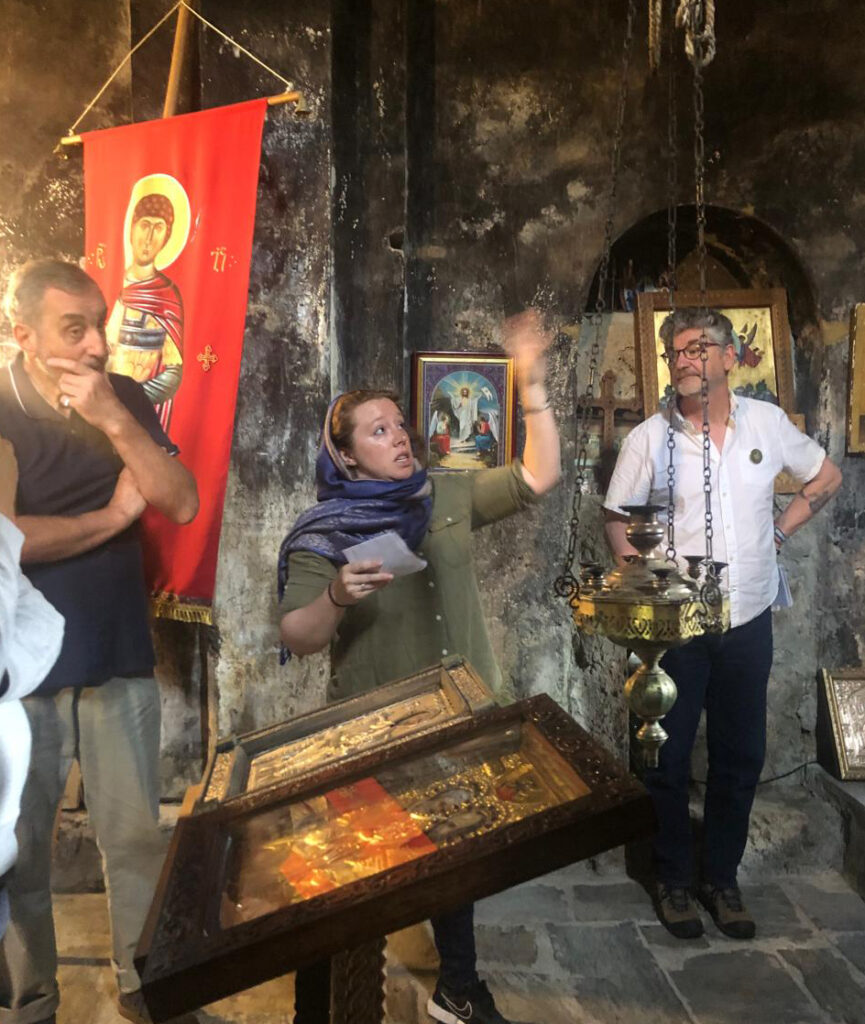 there is a man holding a baby and a woman standing in front of a shrine