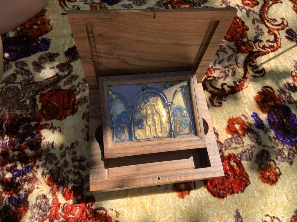 there is a small wooden box with a painting inside of it