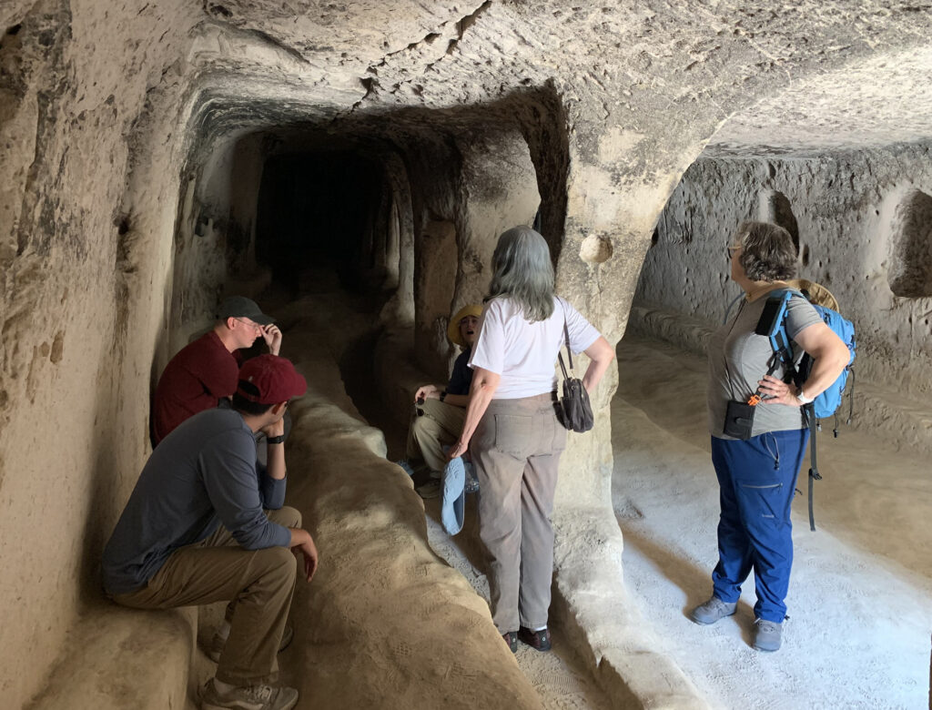 there are three people that are standing in a cave looking at something