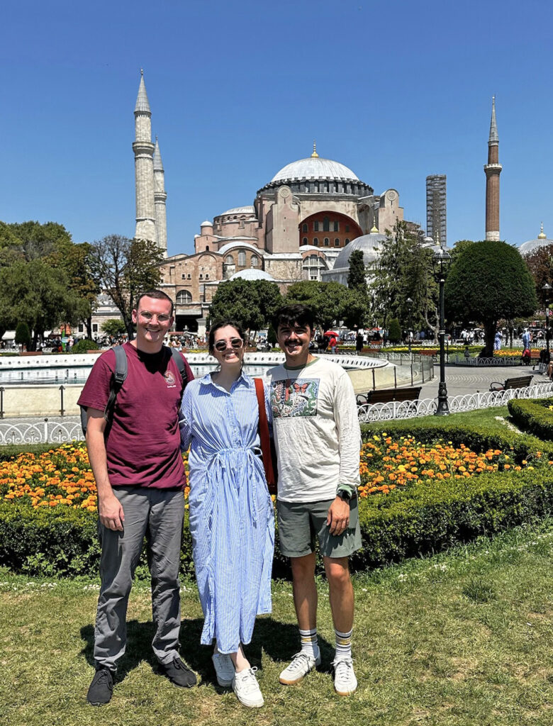 there are two men and a woman standing in front of a building