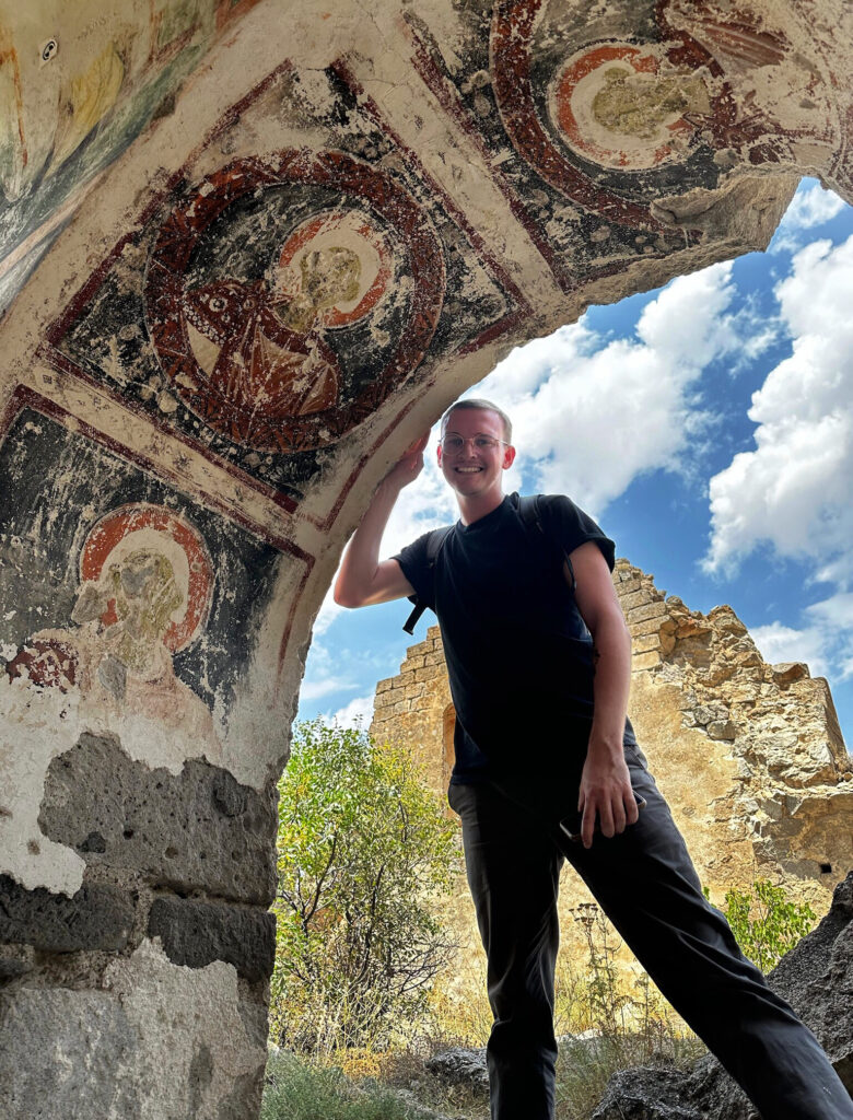 there is a man that is standing in front of an arch