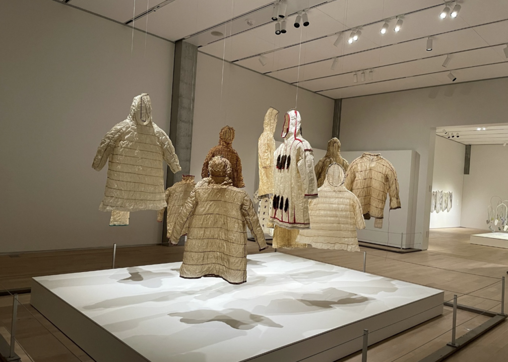 there are many pieces of clothing on display in a museum