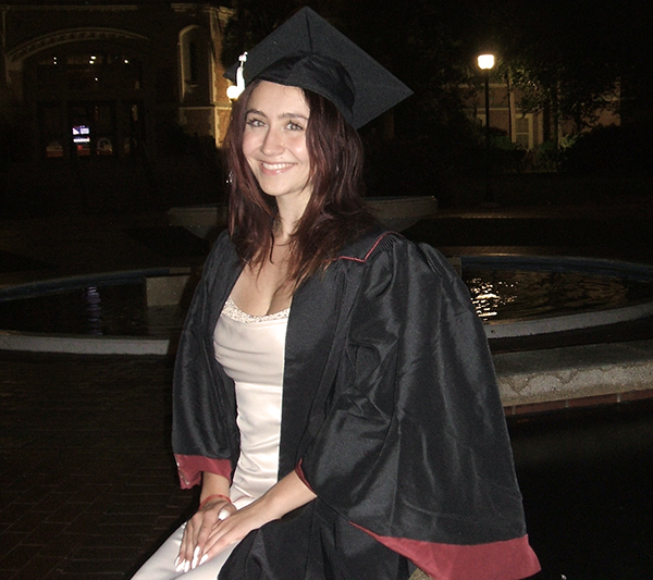 there is a woman in a graduation cap and gown posing for a picture
