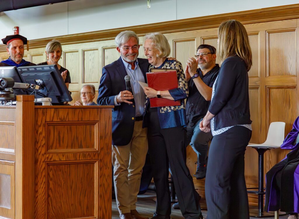 there is a man and woman standing at a podium in front of a group of people