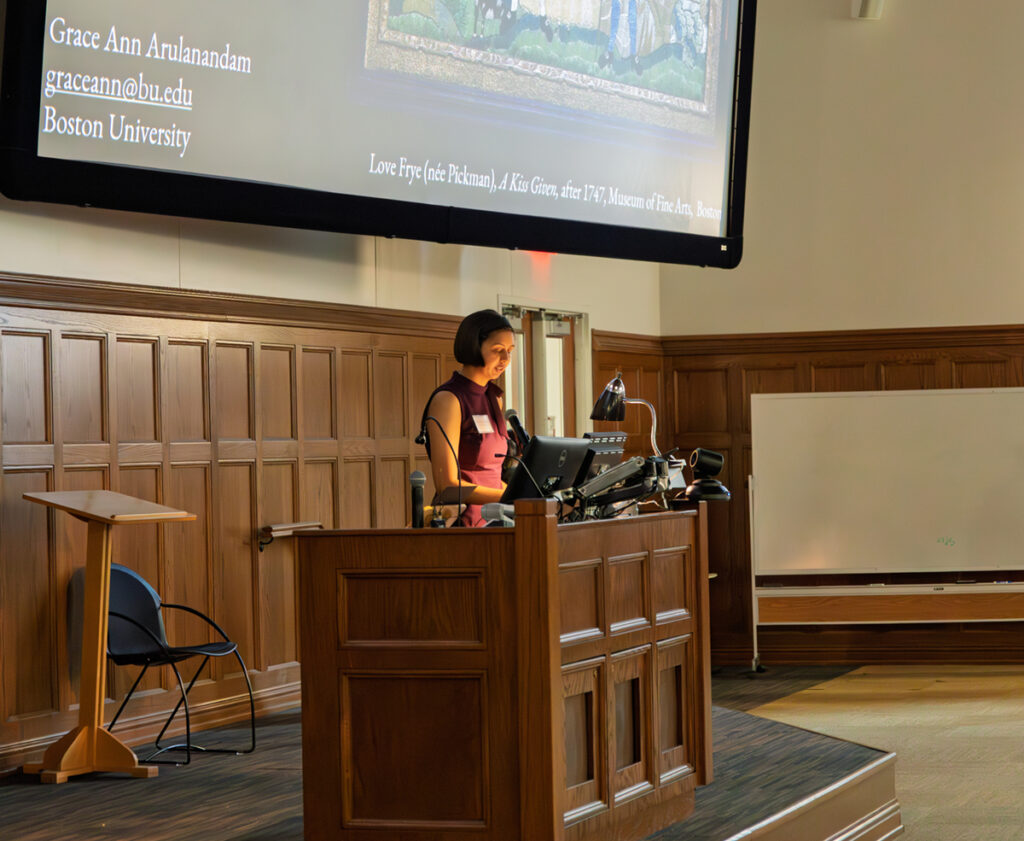 there is a woman that is standing at a podium in front of a projector screen