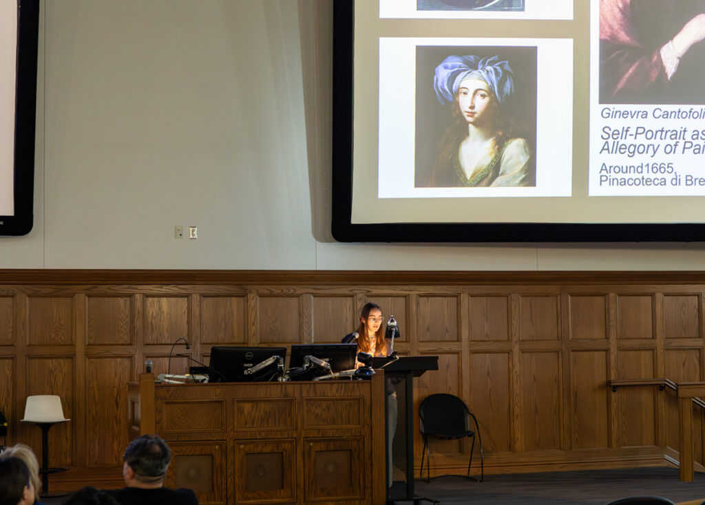 there is a woman that is standing at a podium in front of a projector screen