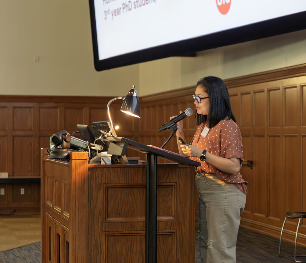 there is a woman standing at a podium with a microphone in front of her