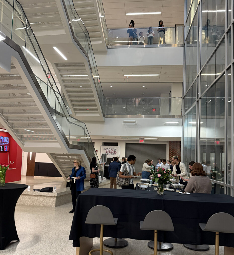 there are people standing in the lobby of a building with a table and chairs