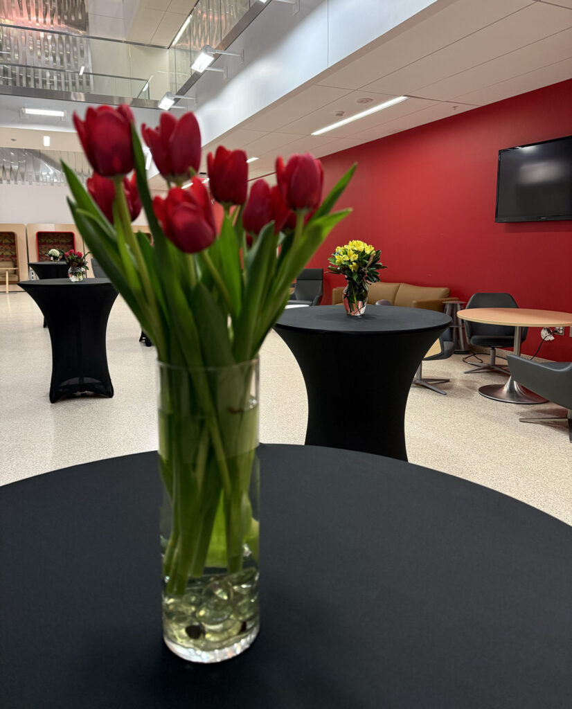 there is a vase with red tulips sitting on a black table