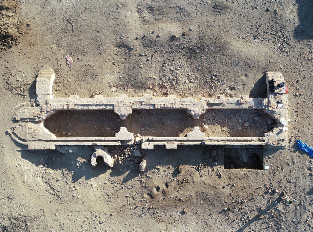 an aerial view of a water trough in the middle of a dirt field