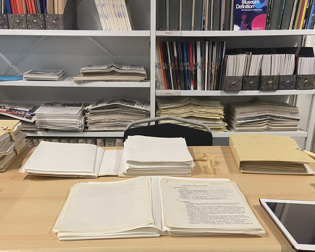 there is a desk with a lot of books and a tablet on it