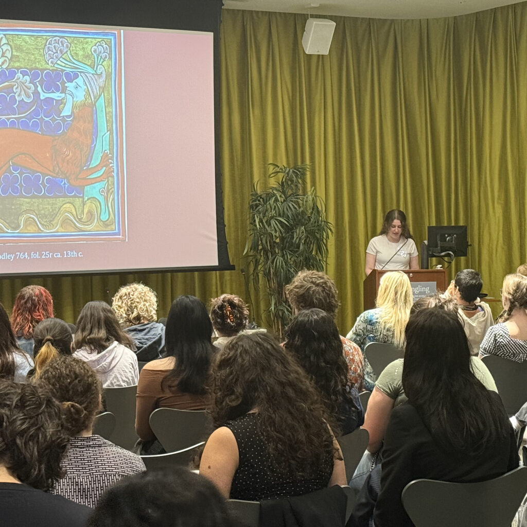 there is a woman standing at a podium in front of a crowd of people