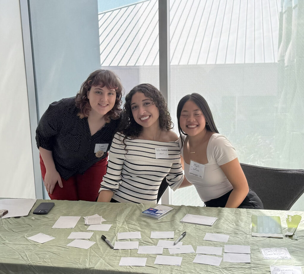 there are three women sitting at a table with papers on it
