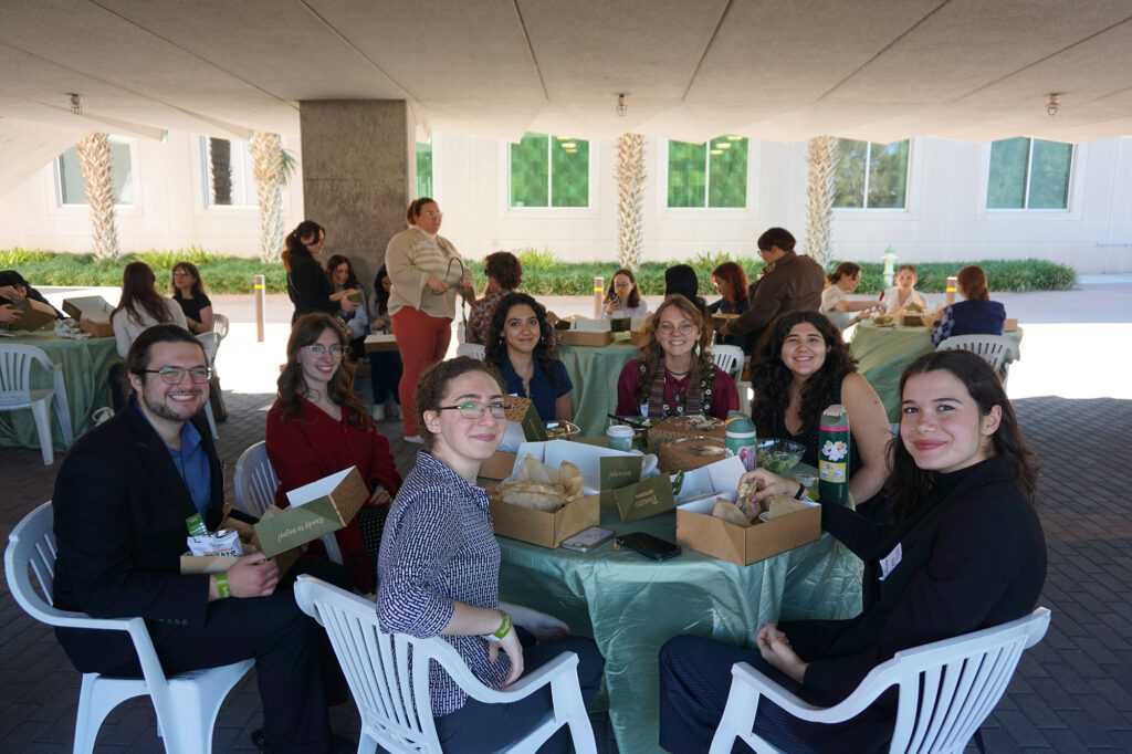 there are many people sitting around a table with food and drinks