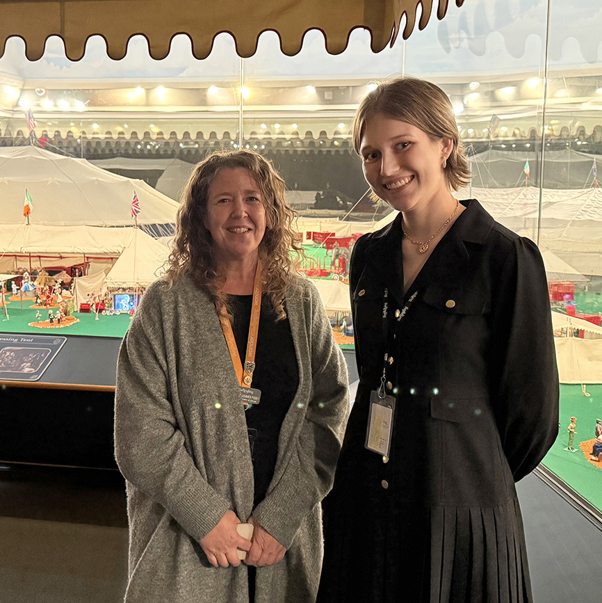 there are two women standing next to each other in front of a glass wall