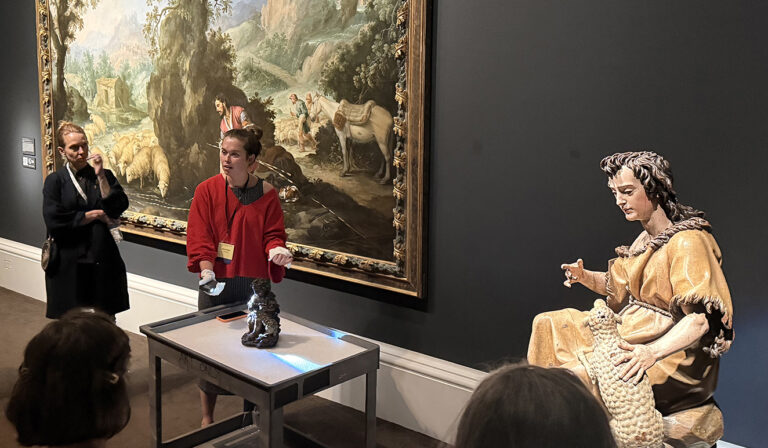 there is a man and a woman standing in front of a painting