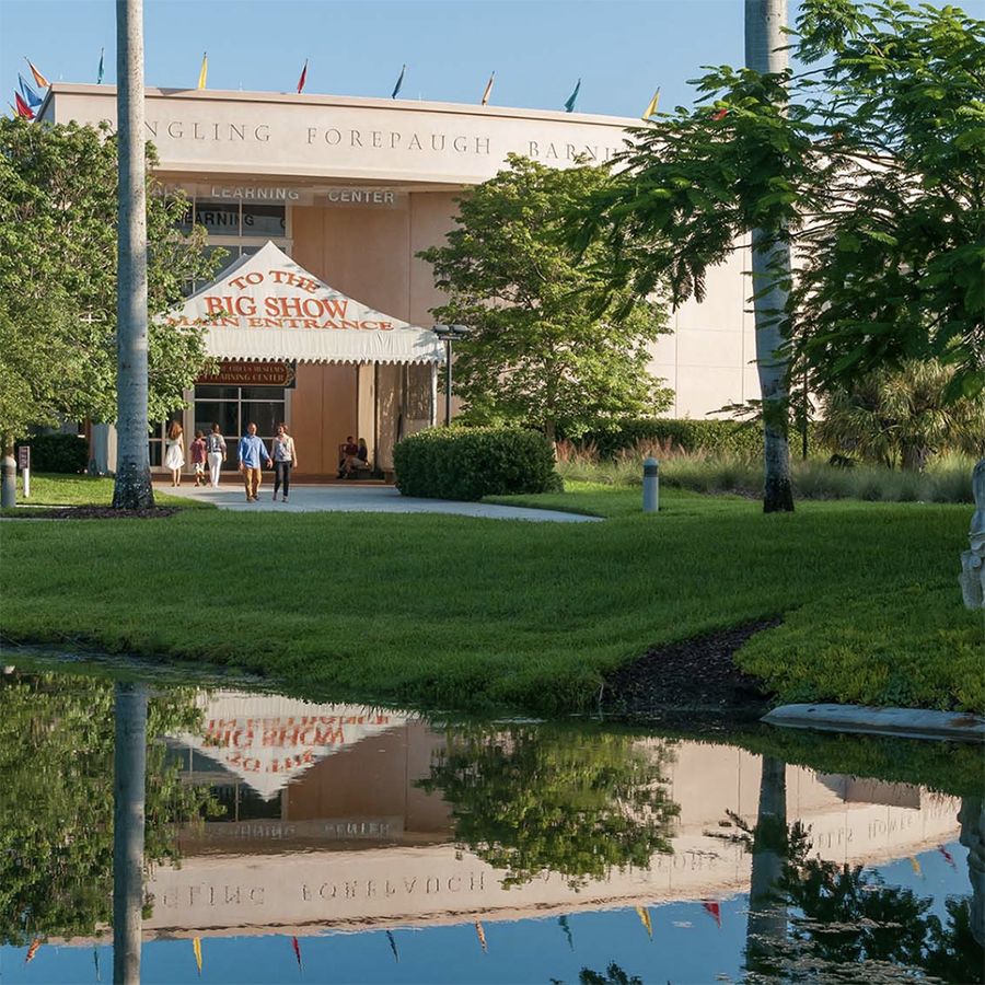there is a reflection of a building in the water of a pond