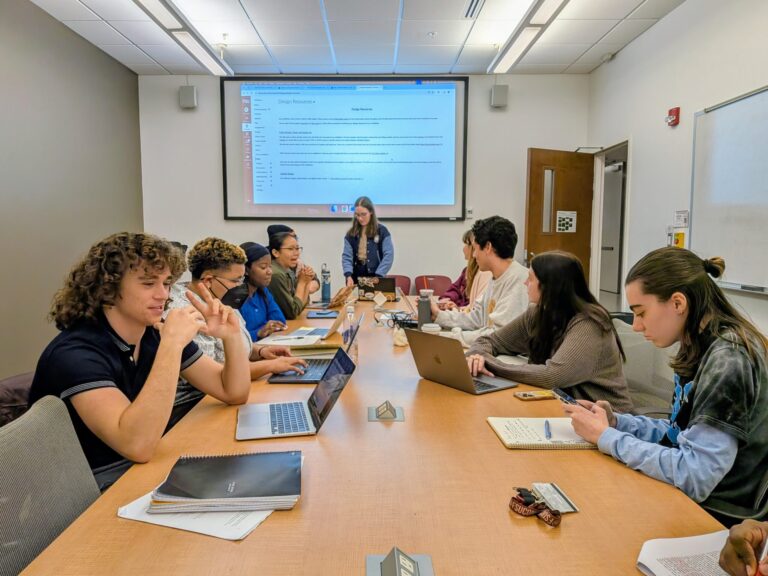 Students at a large table in a classroom setting